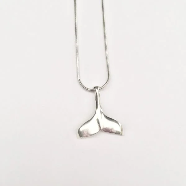 A whale tail on a silver necklace